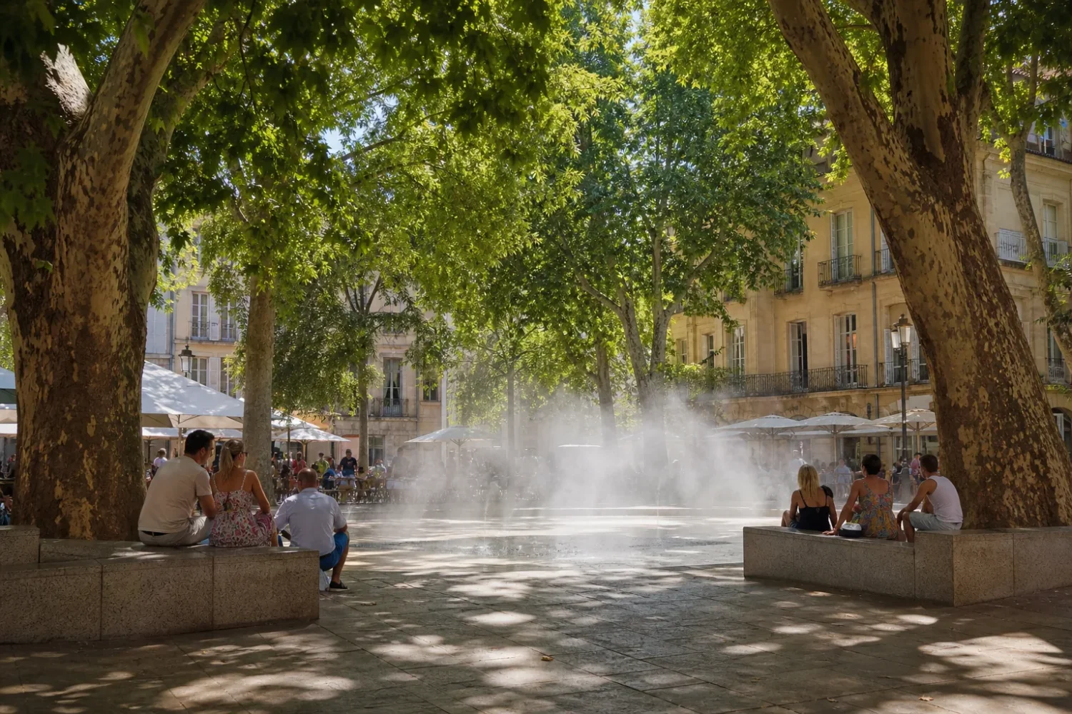 Rue piétonne d'une ville française sous forte chaleur, arbres récemment plantés et brumisateurs en fonctionnement.